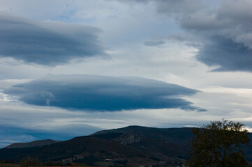 A landscape view of a cloudy sky over a mountain range.