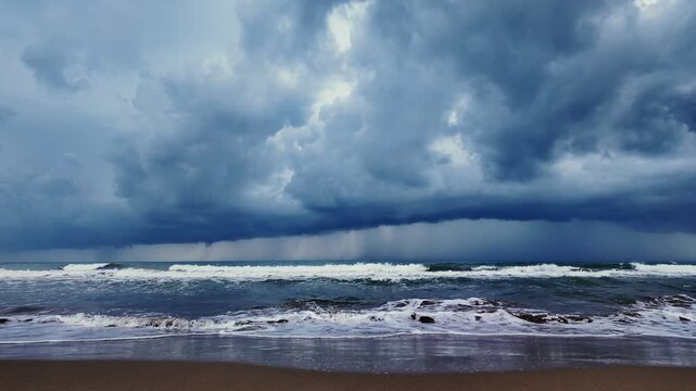 Captivating shot of turbulent sea against Turkish beach backdrop, featuring dark storm clouds gathering overhead, foreshadowing fierce ocean activity during day, slow motion