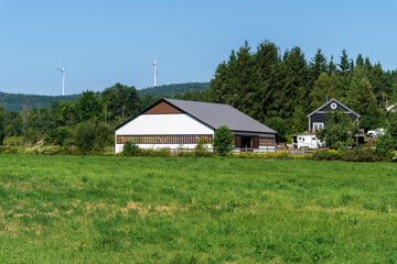 Fototapeta premium A horse training facility with wind turbines in the background
