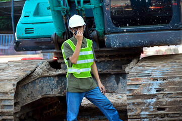 A male engineer is using a radio to give orders.