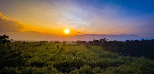 sunrise, sunset, mountain, landscape, nature, rural, field, grass, trees, mist, golden hour, scenic, peaceful, countryside, sky, clouds, horizon, twilight, outdoor, panorama, valley, farmland, meadow,