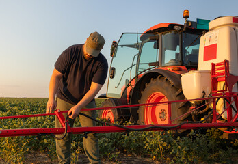 farmer working on tractor sprayer for plant protection, preparation for work.