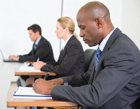 Business professionals attending a seminar taking notes in a classroom