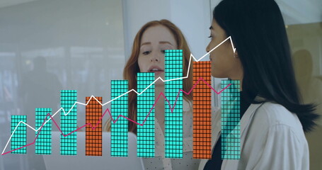 Reviewing digital charts, two colleagues working in office, with laptop and translucent graphs