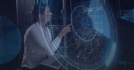 Kneeling technician pointing laptop at rack in server room monitoring holographic UI, copy space