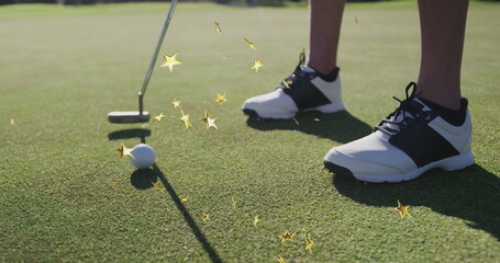 Aligning golfer's legs next to golf ball on putting green, with putter and black-and-white shoes