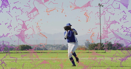 Hispanic baseball player wearing blue jersey catching ball in outfield, with leather glove and cap