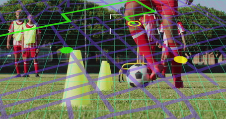 Dribbling teenage boy in red uniform navigating field with soccer ball, neon cones and neon grid