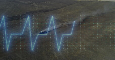 Displaying neon-blue ECG waveform overlay on arid plain, with off-road vehicle kicking dust plume