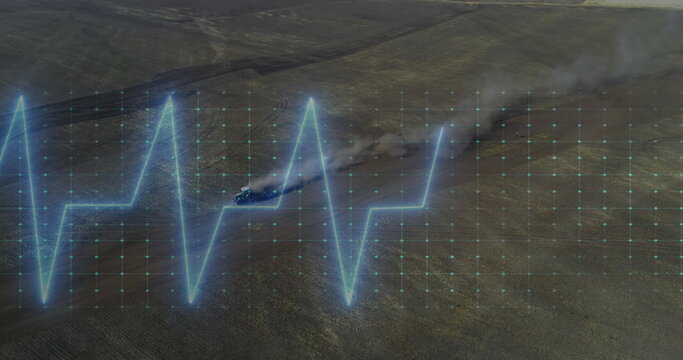 Displaying neon-blue ECG waveform overlay on arid plain, with off-road vehicle kicking dust plume