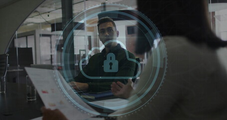Listening man wearing shirt watching colleague speaking in conference room with cloud lock overlay