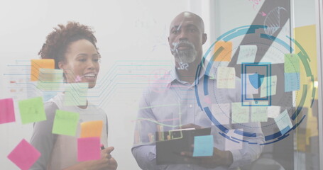 Professionals standing at glass wall in office with Post it notes clipboard pen security overlay