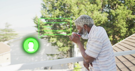 Leaning man sipping mug on balcony wearing surgical mask with green UI overlays, copy space