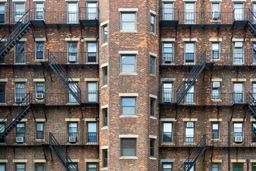 Symmetrical brick apartment building with black metal fire escapes in Boston, Massachusetts, USA 
