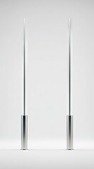 Two slender, brushed-metal poles stand upright on a minimalist white background, their cylindrical bases slightly wider than their tall, thin shafts