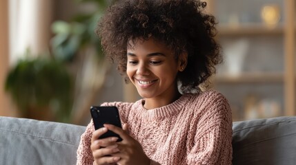 smiling afro american millennial woman user holding smart phone watching video playing game shopping chatting in mobile technology application sitting on sofa at home close up view banner design no l