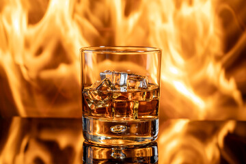 Glass of whiskey on table with fire in background
