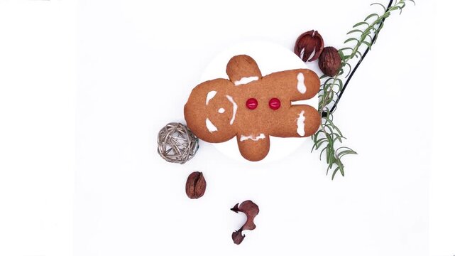 Holiday gingerbread cookie with red candy buttons, turning alongside the walnut and fresh rosemary decorations lock dawn camera top view
