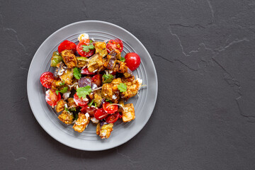  Georgian salad with deep fried eggplant, tomatoes, onions, feta cheese and cilantro. Vegetarian food with eggplant and other vegetables, top view copy space for text