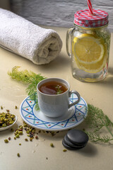Fennel tea with lemon water bottles and a towel. A healthy and wellness concept