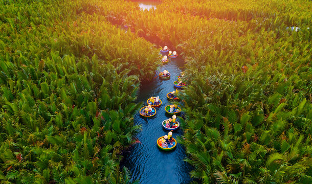 Scenic aerial view of round boats in hoi an waterways surrounded by lush greenery, travel banner for Vietnam - Powered by Adobe