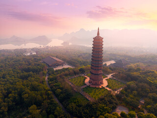 Sunset over Ninh Binh pagoda and scenic landscape with lush greenery and mountains