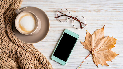 Cozy Autumn Still Life with Coffee Blanket Mobile Phone and Maple Leaf on White Wooden Tabletop for Fall Season Relaxation