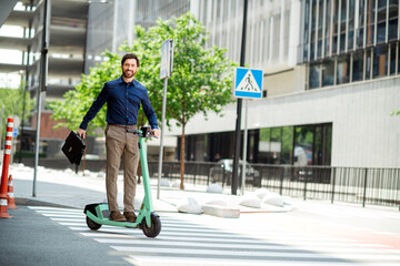 Professional young man rides electric scooter in an urban cityscape holding a briefcase, reflecting modern and sustainable work lifestyle © deagreez