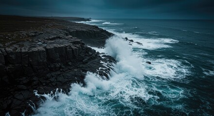 Fototapeta premium Tempestuous Ocean Waves Crash Against Jagged Black Cliffs Under a Dark, Moody Sky.