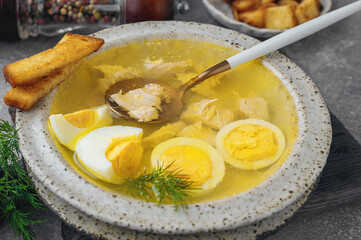 chicken broth with egg. Chicken soup with pieces of boiled fillet and halves of a quail egg. The soup is served with croutons