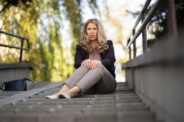 Portrait of a beautiful young blonde girl in a city park.