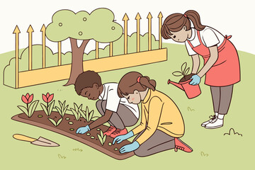 Focused kids planting seedlings in the school garden during outdoor class.