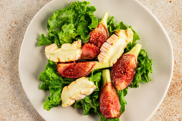 Salad figs, soft cheese, green leaf lettuce tasty snack fresh delicious gourmet food background on the table rustic food top view copy space keto and paleo diet vegetarian food