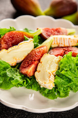 Salad figs, soft cheese, green leaf lettuce tasty snack fresh delicious gourmet food background on the table rustic food top view copy space keto and paleo diet vegetarian food