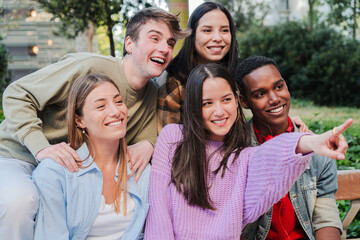 A cheerful group of friends laughing and pointing, capturing a joyful moment together, embodying the essence of friendship and connection among young people as they share an enjoyable experience.