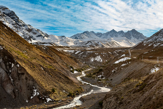 The road to Embalse del Yeso in Chile, offering a glimpse of the Rio Yeso and the surrounding snow-covered mountain landscape.