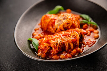 Stuffed cabbage tomato sauce with beans meat, cabbage, fresh delicious gourmet food background on the table rustic food top view copy space