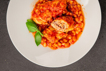 Stuffed cabbage tomato sauce with beans meat, cabbage, fresh delicious gourmet food background on the table rustic food top view copy space