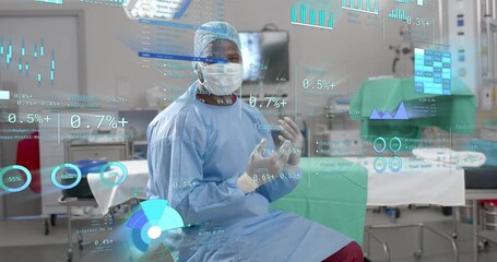 Mid adult surgeon raising gloved hands initiating holographic health charts for monitoring in OR - Powered by Adobe