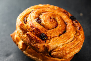 Obraz premium Raisin bun sweet pastry dessert puff pastry fresh delicious gourmet food background on the table rustic food top view copy space