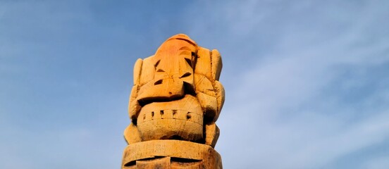 Intricate wooden sculpture of Lord Ganesha against a clear blue sky, Lord Ganesha idol festival...
