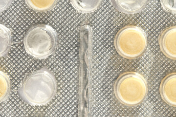 close up of blister pack with circular pills in transparent packaging for medication or supplement use.