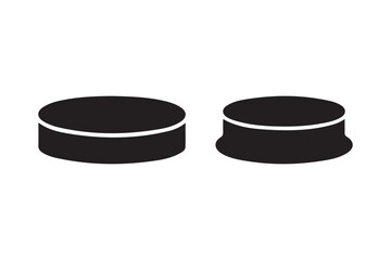 Two black hockey pucks on a white background