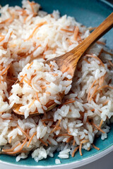 "Close-up of a plate of Turkish rice pilaf with vermicelli, served with a wooden spoon.