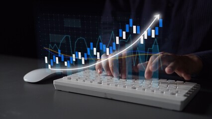 A focused scene featuring hands typing on a keyboard with a background of stock market data visualization, highlighting financial growth and trends in a digital workspace. Copula