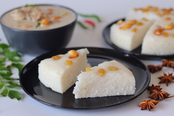 Kerala style vattayappam topped with golden raisins, sliced and served with mutton stew in coconut milk gravy