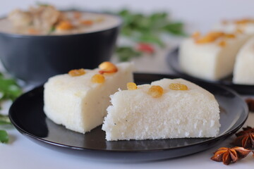 Kerala style vattayappam topped with golden raisins, sliced and served with mutton stew in coconut milk gravy