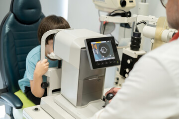 Optometry concept. An optometrist checks a boy's vision in an ophthalmology clinic.