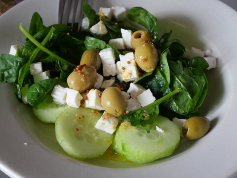entr&eacute;e de salade d'olives avec f&eacute;ta et comcombre et &eacute;pinard avec un aper&ccedil;u de fourchette