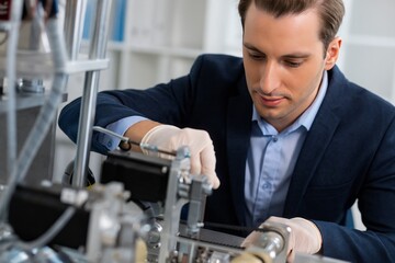 Engineer in a Lab Coat Working on Complex Machinery with Precision and Focus